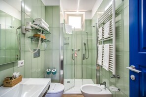 A modern bathroom with a glass-enclosed shower, a white sink, and a blue door. - Palazzo del Barone (Massa Lubrense)