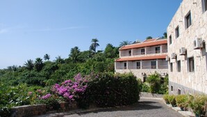 Un edificio con tetto in tegole rosse, pareti in pietra e un balcone.