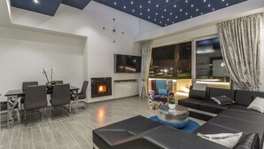 Una sala de estar moderna con chimenea, un comedor y un sofá grande.