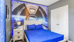 Een slaapkamer met een bed, nachtkastjes, een deur en een muurschildering.