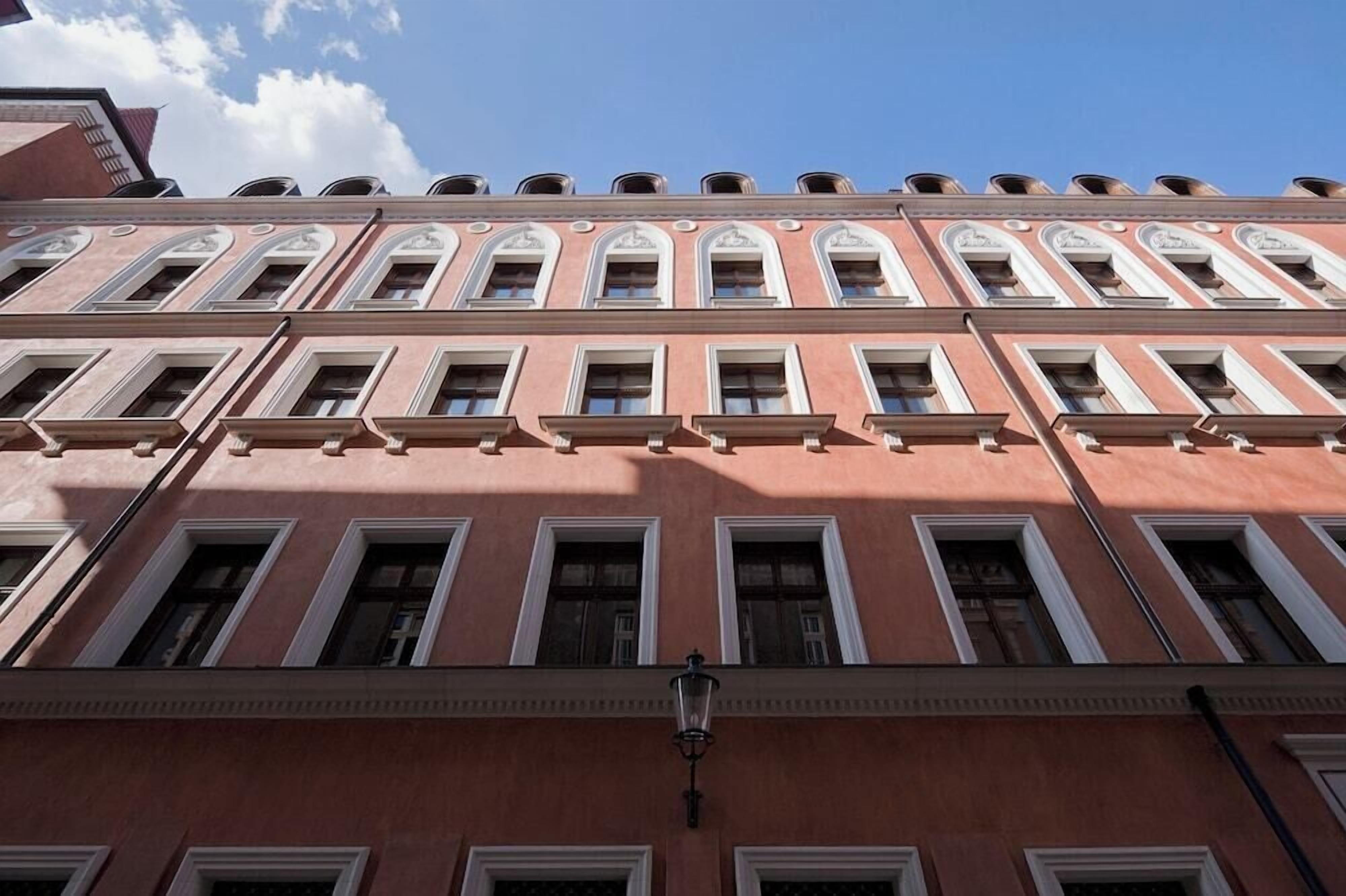 A multi-story building with a symmetrical facade, featuring evenly spaced windows and a central entrance.