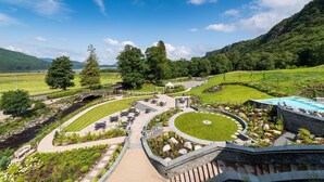 A landscaped outdoor area with a pool, seating areas, and a gazebo. - Lodore Falls Hotel (Keswick)