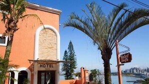 Un hotel amb vistes a una massa d'aigua i un paisatge urbà al fons.