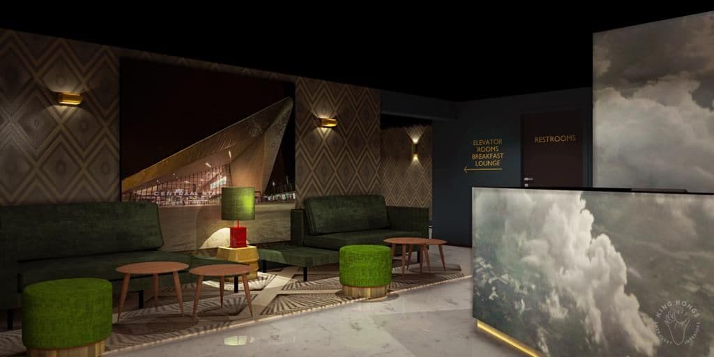 A lounge area with seating, a coffee table, and a wall-mounted screen displaying a landscape.