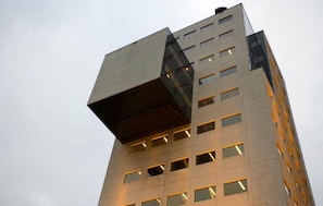 Un edificio moderno caratterizzato da un design angolare originale, numerose finestre e un tetto piatto.