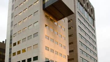 A modern high-rise building with a unique architectural design, featuring multiple floors and a prominent overhang.
