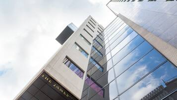 A modern hotel building with reflective glass windows and a prominent sign reading 'The James Hotel.'