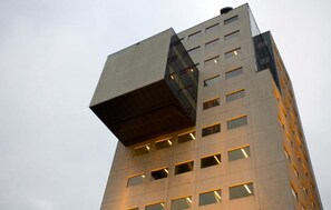 Um edifício moderno com design angular único, várias janelas e telhado plano.