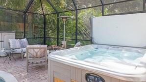 Ein Whirlpool in einem überdachten Außenbereich mit Terrasse, Sitzgelegenheiten und einem Pool.