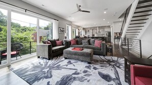 A spacious living area with a sofa, ottoman, and a patterned rug.