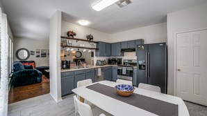 A modern kitchen with grey cabinets, a central island, and a dining area.
