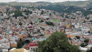 A densely packed hillside town with colorful buildings and a prominent church on a hilltop. - Hotel Casa Autora 40 (Guanajuato)