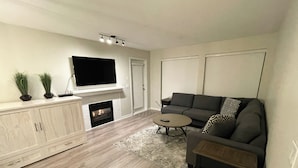 A modern living room with a fireplace, a flat-screen TV, a sectional sofa, and a coffee table. - Modern, Deluxe Stoney Creek Northstar Condo. Pool & Hot Tub, Gas Fireplace (Whistler)
