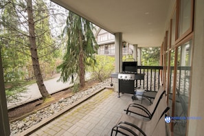 Enjoy al fresco dining and social gatherings in this outdoor patio area, complete with a grill, table, and chairs.