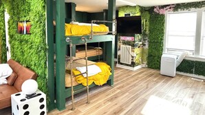 A bunk bed with green walls and a 'Pig Lover' sign, a brown couch, and a dice-shaped object on the floor.