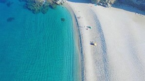 An aerial view of a beach with clear turquoise waters, rocky formations, and a sandy shore. - House "Amazing Duplex - 30m from the beach" with Sea View, Terrace, A/C & Wi-Fi (San Juan de los Terreros)