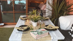 A dining table set with plates, cutlery, a candle, and a decorative plant. - House "Amazing Duplex - 30m from the beach" with Sea View, Terrace, A/C & Wi-Fi (San Juan de los Terreros)