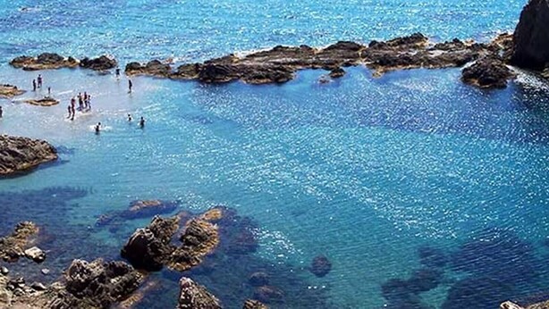 A coastal area with clear blue water, rocky formations, and people swimming. - House "Amazing Duplex - 30m from the beach" with Sea View, Terrace, A/C & Wi-Fi (San Juan de los Terreros)