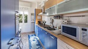 A modern kitchen with a microwave, sink, and wooden cabinets.