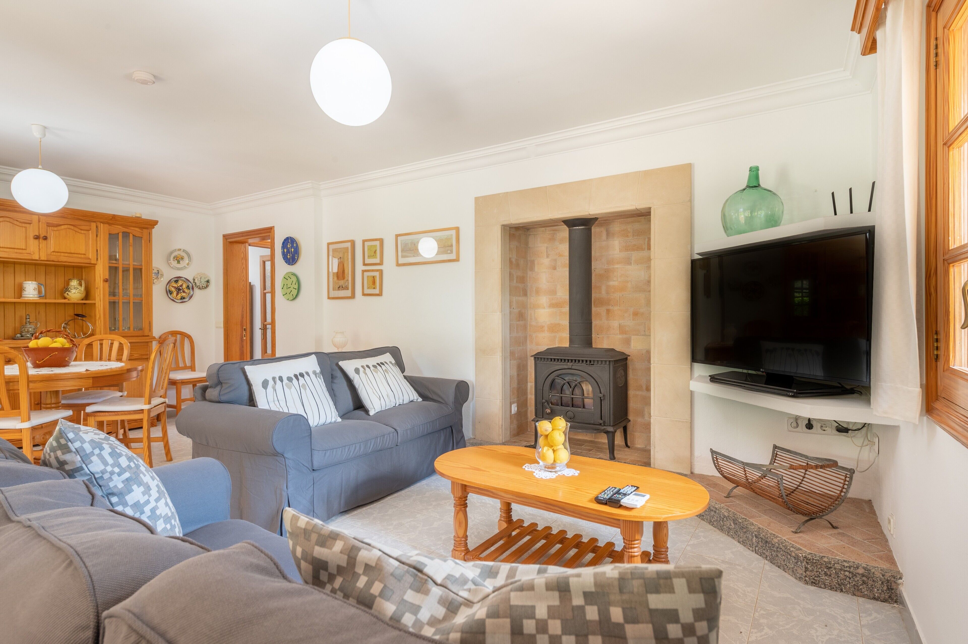 Ein Wohnzimmer mit Sofa, Couchtisch, Fernseher, Kamin und Essbereich.