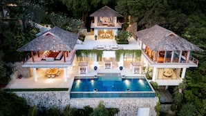 Une maison luxueuse dotée d’une grande piscine, de plusieurs espaces de détente en plein air et d’un jardin bien entretenu.