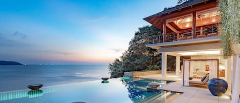 Una piscina al aire libre, sombrillas, sillones reclinables de piscina