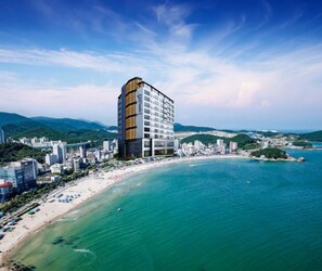 A high-rise hotel with a modern design, located near a beach with clear turquoise waters. - Song Jeong Hotel Blue Castle (Busan)