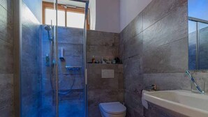 A bathroom with a glass-enclosed shower, a toilet, and a sink with a mirror. - Junior Suite JS - Haus Weyregg - Frühstückspension (Weyregg am Attersee)