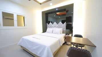 Una habitación de hotel moderna con una cama bien hecha, una mesita y una silla.