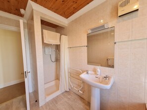 A bathroom with a shower, a sink, and a toilet. - Sea View Cottage, Errislannan (Clifden)