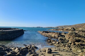 A rocky coastal area with a stone pier extending into the sea. - Sea View Cottage, Errislannan (Clifden)