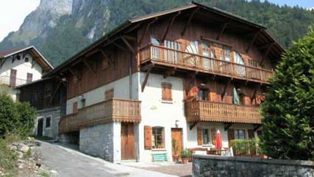 A traditional chalet with wooden balconies, set against a mountainous backdrop. - 3-room apartment with balcony and parking in Samoëns (Samoëns)