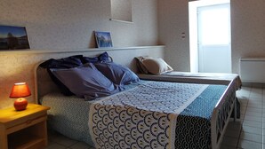A bedroom with a bed, bedside table with a lamp, a window, and a picture on the wall. - Family cottage with yard, ping-pong, near Lyon and Clermont-Ferrand (Mézères)