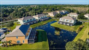A residential area with houses, a central water feature, and a parking lot. - Great NEW 4 bedroom townhouse in Hidden Forest, with private pool! (Clermont)