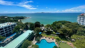 Un complexe hôtelier doté d’une piscine, d’une végétation luxuriante et offrant une vue sur la mer.
