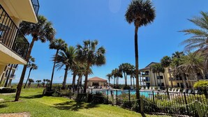 Un complexe hôtelier doté d’une piscine, de palmiers et d’un bâtiment avec des balcons.