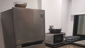Een keuken met een roestvrijstalen koelkast, een magnetron en een broodrooster.
