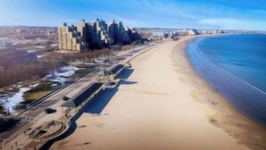 Une plage avec la silhouette d’une ville en arrière-plan.