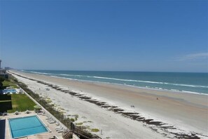 A beach with a pool and lounge chairs, a clear sky, and the ocean. - Perfect Location in Ponce Inlet for this 2/2 oceanfront Condo 504 South Point (Ponce Inlet)