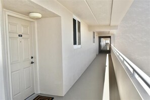 A hallway with a white door marked '504', a window, and a railing along the right side.