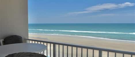 Ein Balkon mit Blick auf Strand und Meer.