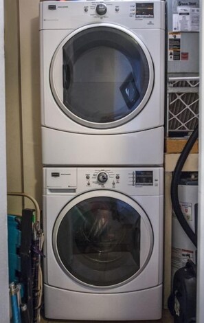 Two stacked front-loading washing machines in a utility room.