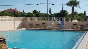Une piscine rectangulaire à l’eau d’un bleu limpide, entourée d’une terrasse carrelée.