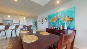 A dining area with a wooden table, woven placemats, and chairs. - A Wave From Everything (Bolivar Peninsula)