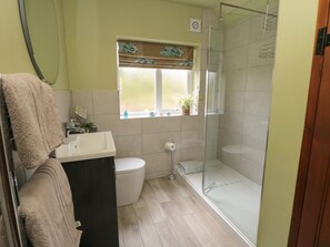 A bathroom with a toilet, sink, and glass shower stall.