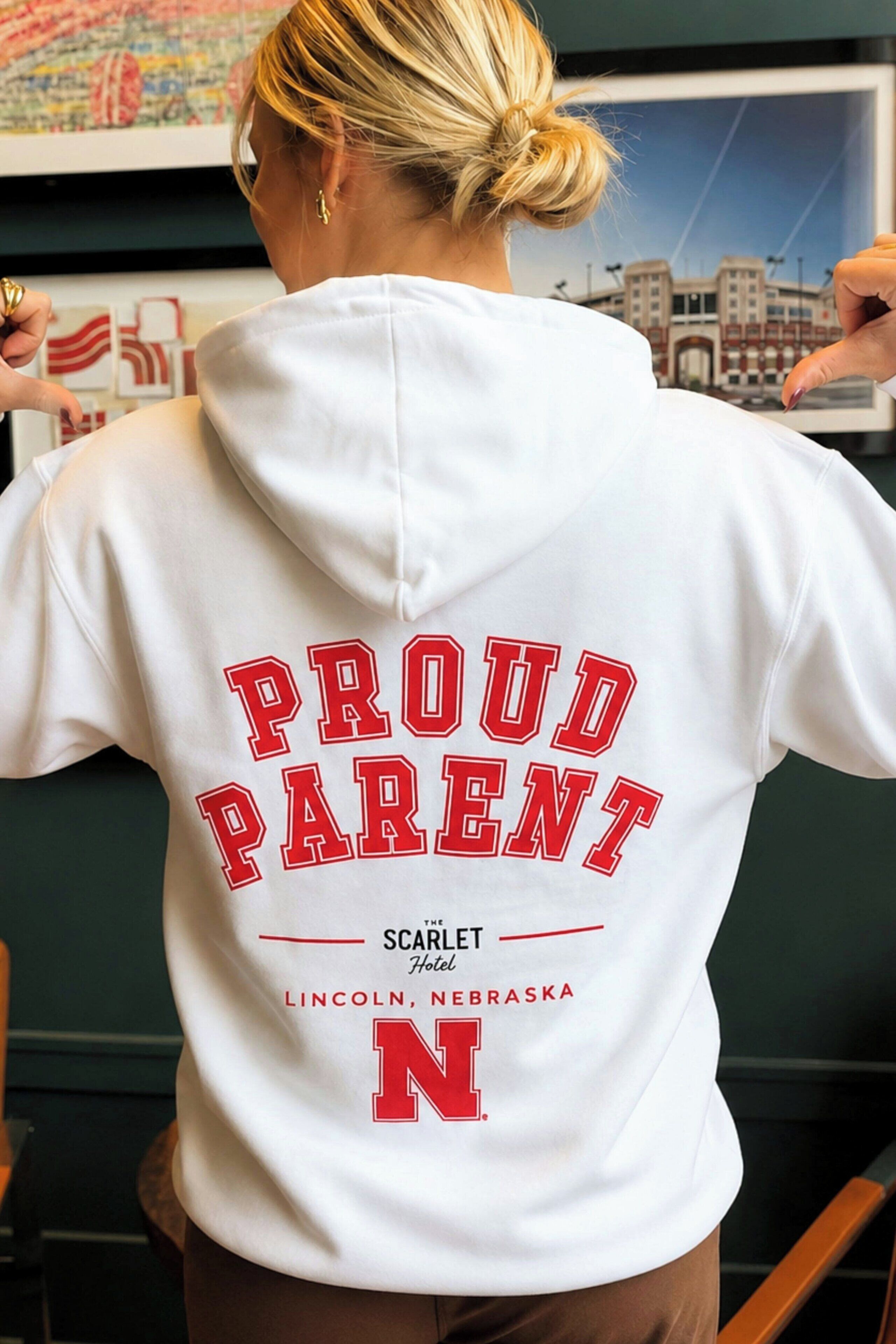 Una persona con una sudadera que dice 'PROUD PARENT' y 'LINCOLN, NEBRASKA', indicando una ubicación.