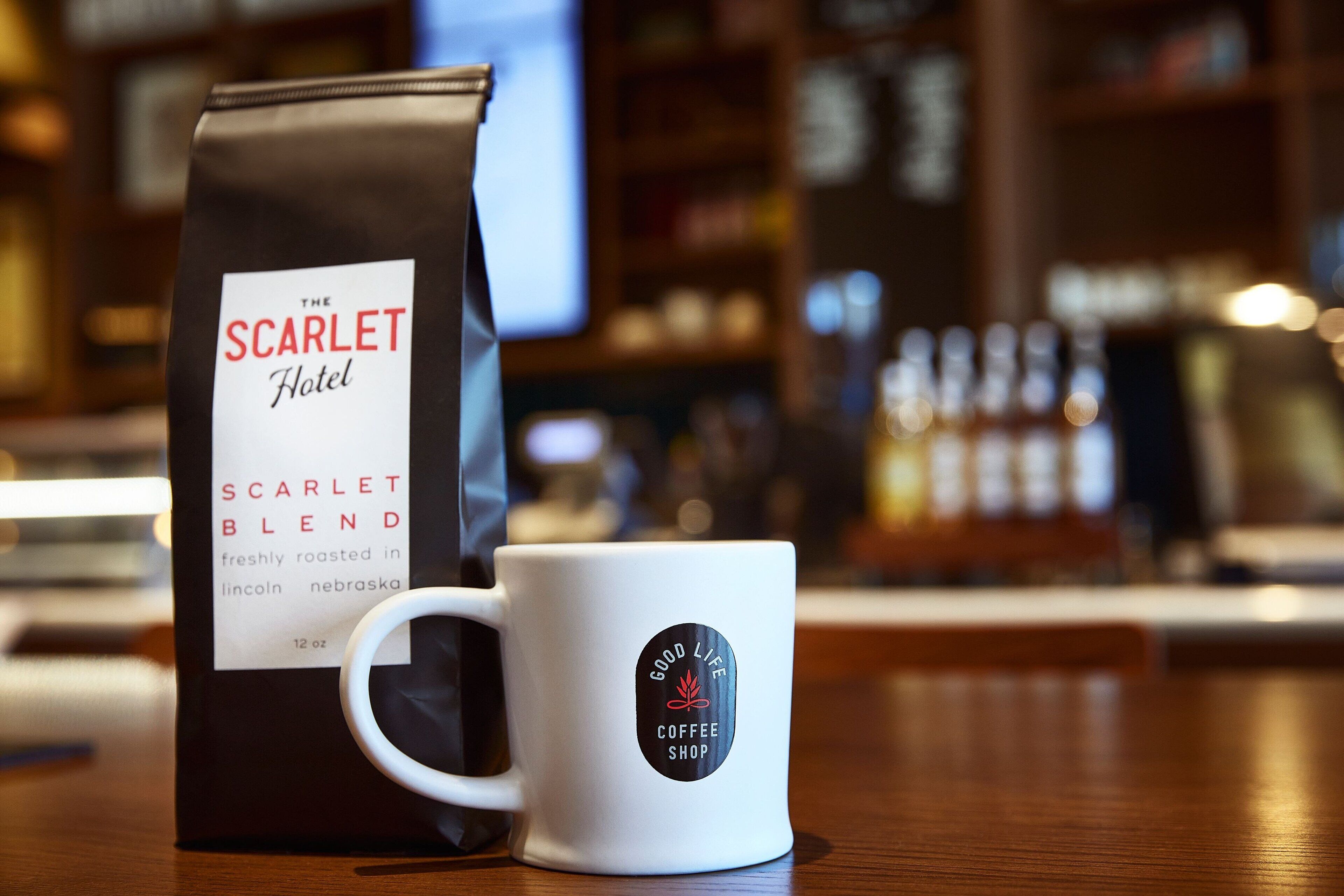 A coffee bag and mug on a wooden table with a blurred background.