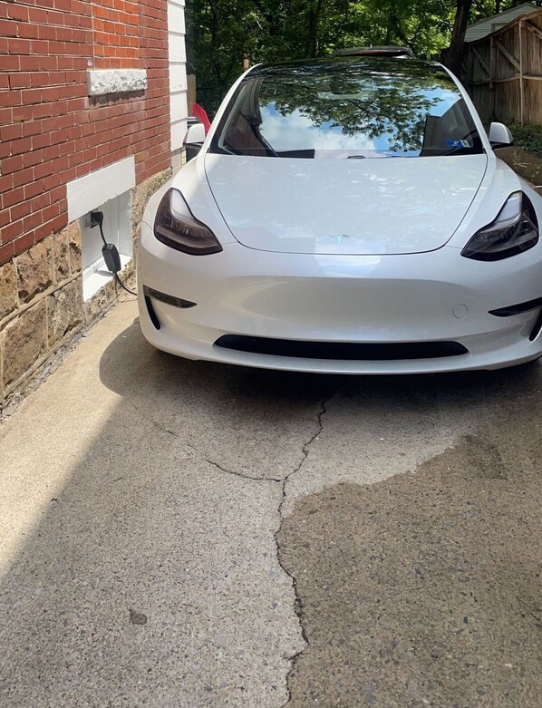 A white sports car parked in a driveway with a brick wall and a wooden fence in the background. - Sittos 100ft from WVU Tech, 2 bedroom home between New River Gorge and Grandview (Beckley)
