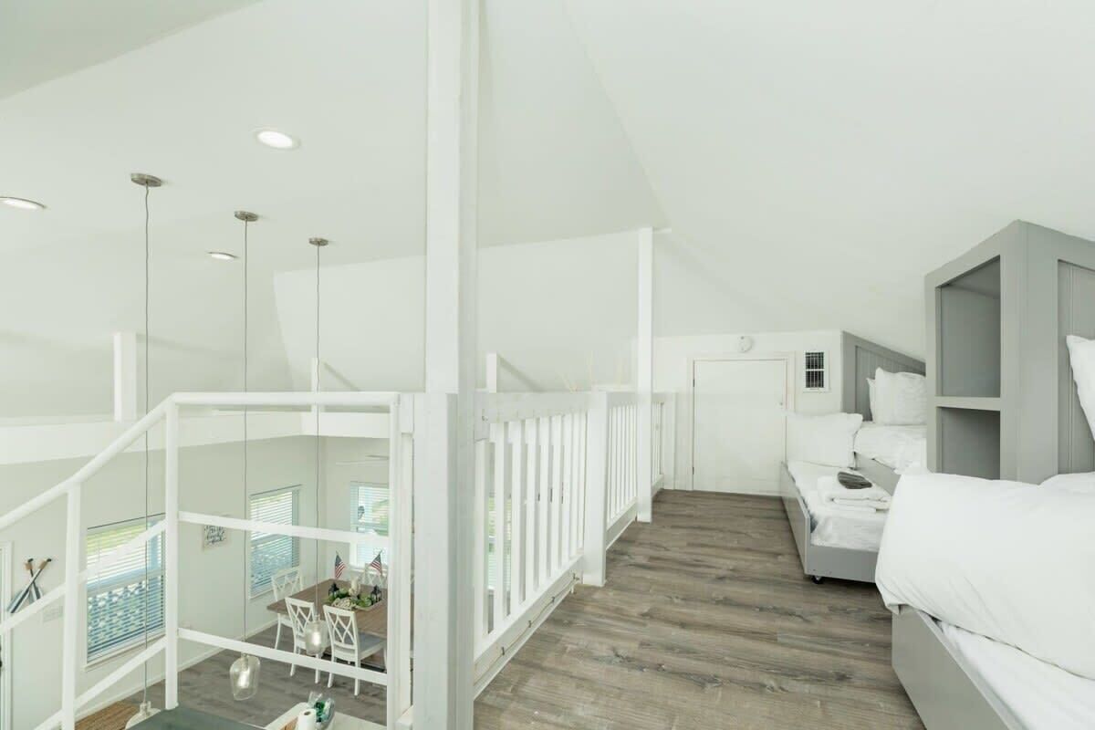 Ein modernes Interieur mit Treppe, einem Bett und einem Essbereich.