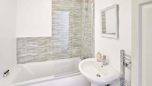 Un baño moderno con bañera, lavabo y ducha.